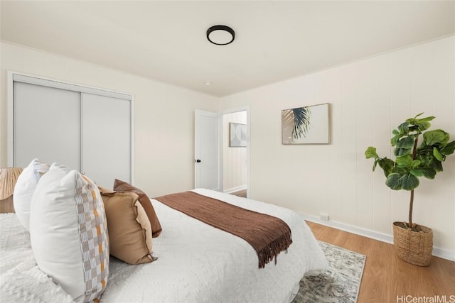 bedroom featuring a closet, baseboards, and wood finished floors