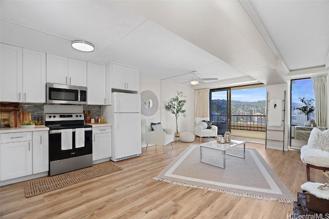 kitchen featuring decorative backsplash, ceiling fan, white cabinetry, light hardwood / wood-style floors, and stainless steel appliances