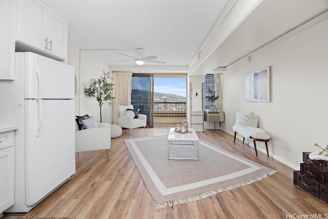 living room featuring light wood-type flooring and ceiling fan