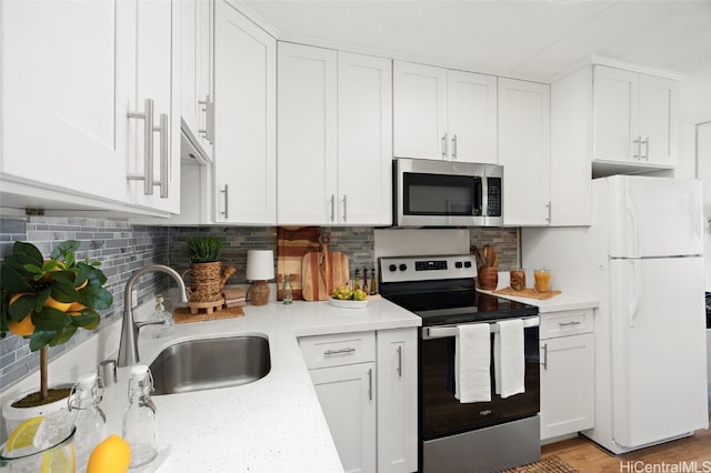 kitchen featuring sink, white cabinetry, stainless steel appliances, and tasteful backsplash