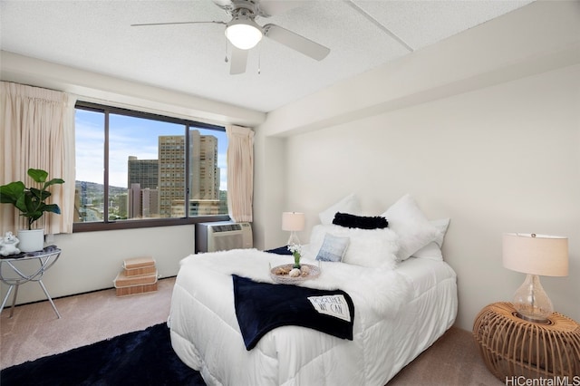 bedroom featuring a textured ceiling, cooling unit, carpet floors, and ceiling fan