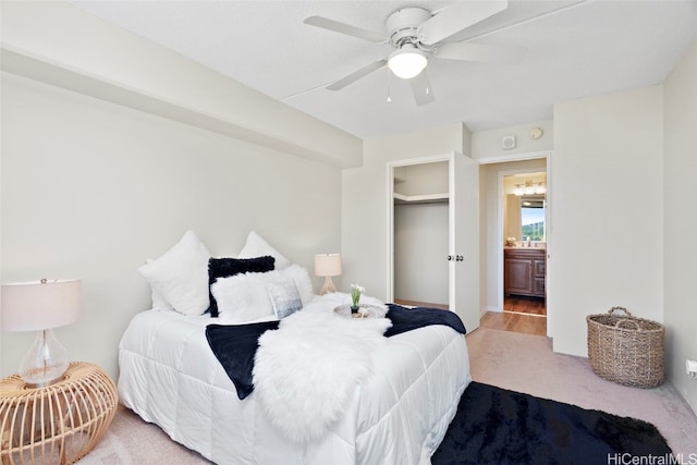 carpeted bedroom with a closet, ceiling fan, and ensuite bathroom