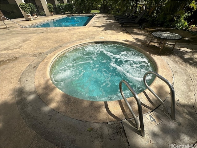 view of pool featuring an in ground hot tub and a patio area