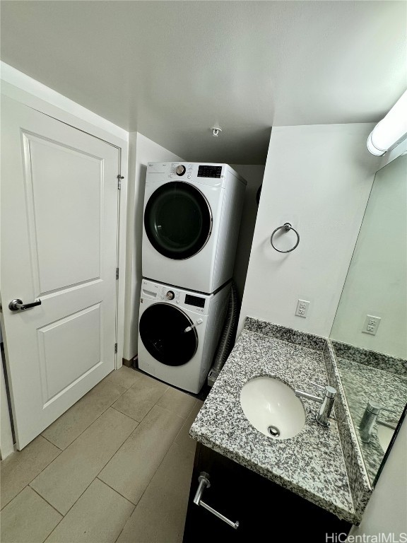 laundry room with sink, stacked washer / dryer, and light tile patterned floors