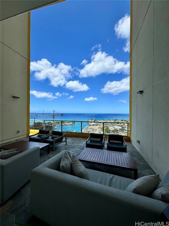 view of patio / terrace featuring an outdoor living space, a view of the beach, and a water view