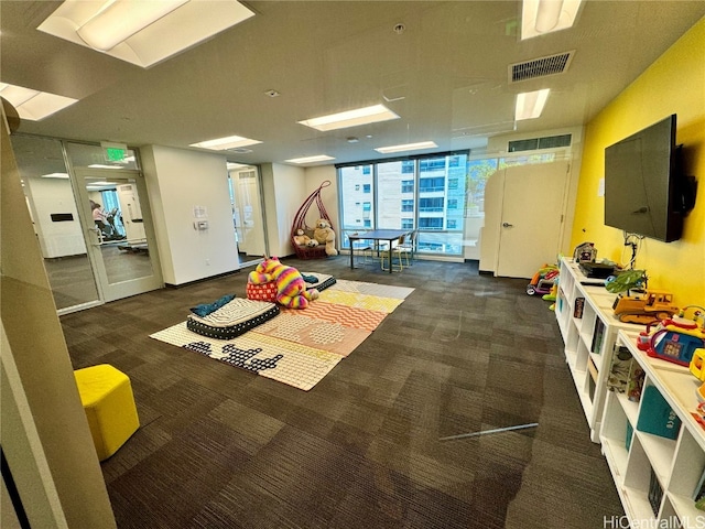 game room featuring expansive windows and dark colored carpet