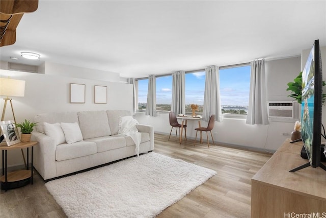 living room featuring cooling unit, light hardwood / wood-style flooring, and plenty of natural light