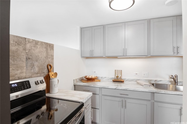 kitchen featuring stainless steel electric range oven, gray cabinetry, and a sink