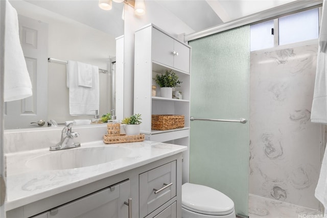 bathroom featuring toilet, a marble finish shower, and vanity