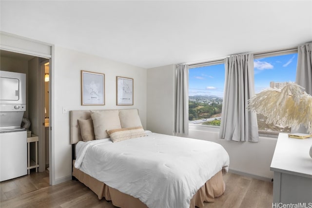 bedroom with stacked washer / dryer and light hardwood / wood-style floors