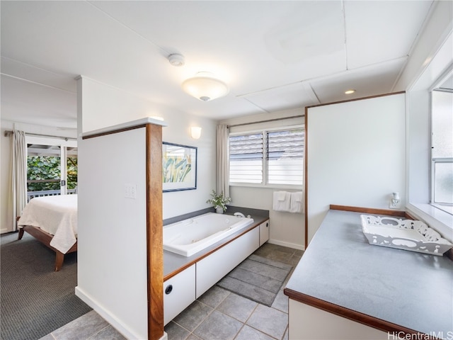 bathroom featuring vanity, a healthy amount of sunlight, a bath, and tile patterned flooring