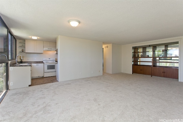 kitchen featuring white electric range, sink, white cabinets, light colored carpet, and a textured ceiling