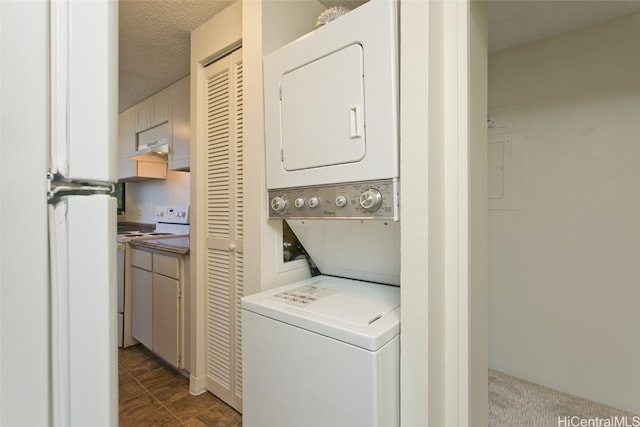 washroom with stacked washer / dryer and a textured ceiling