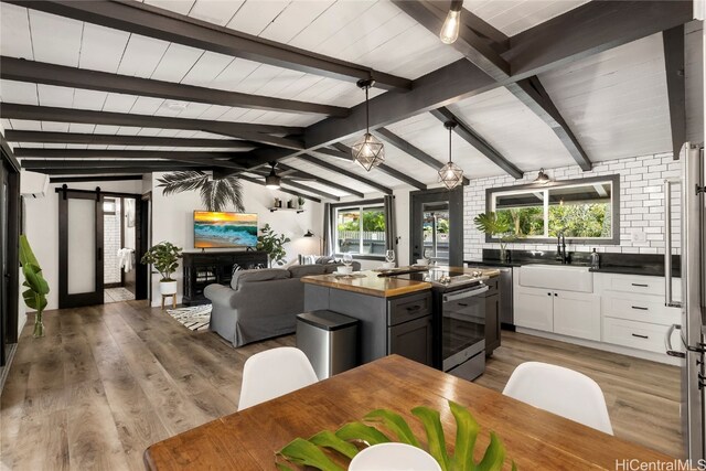 kitchen with white cabinetry, stainless steel range with electric stovetop, wood-type flooring, and a healthy amount of sunlight