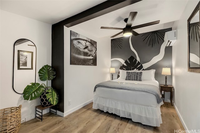 bedroom featuring ceiling fan, an AC wall unit, beam ceiling, and light wood-type flooring