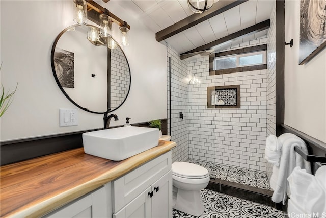 bathroom with vaulted ceiling with beams, toilet, wooden ceiling, tiled shower, and vanity