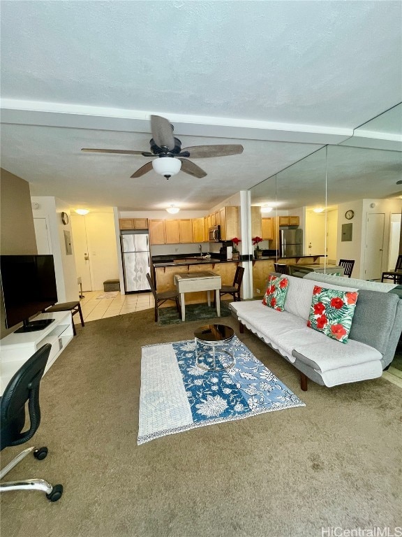 carpeted living room with a textured ceiling and ceiling fan