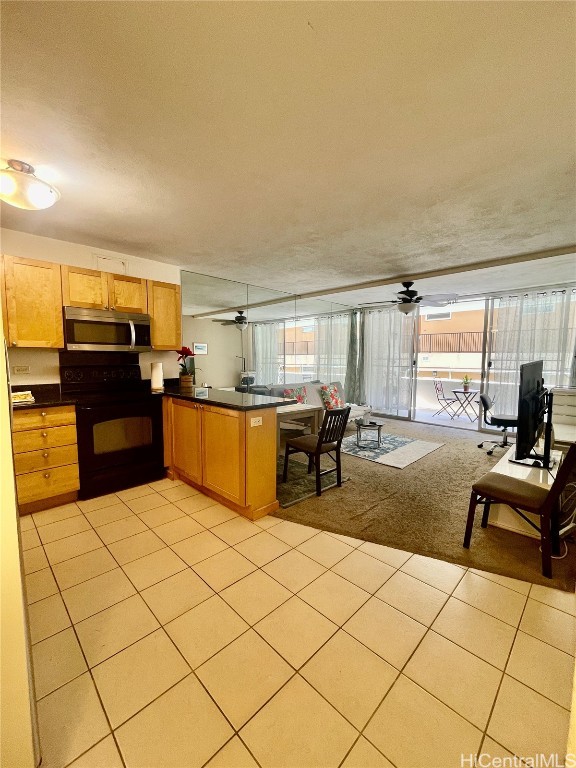 kitchen featuring black range, a textured ceiling, kitchen peninsula, ceiling fan, and light tile patterned floors