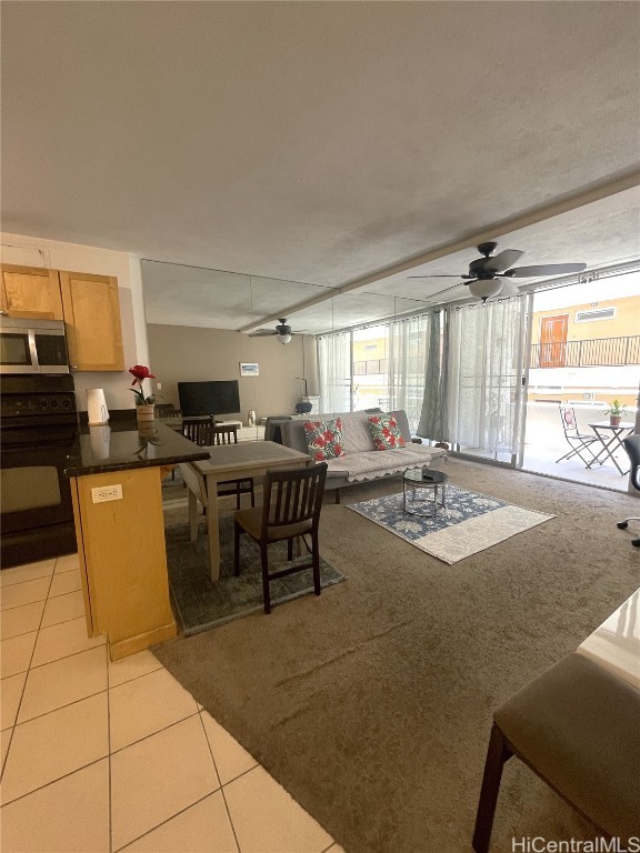 living room featuring light tile patterned flooring and ceiling fan