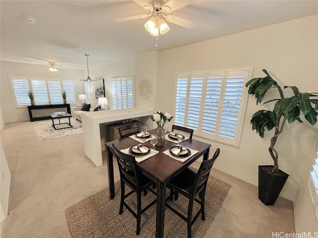 carpeted dining space featuring ceiling fan