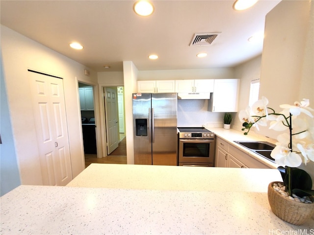 kitchen with kitchen peninsula, white cabinetry, and stainless steel appliances