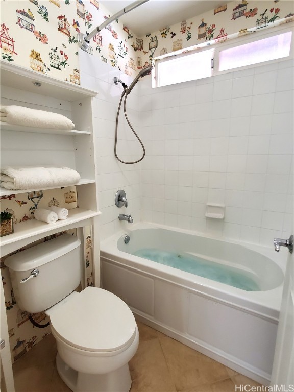 bathroom featuring toilet, tile patterned floors, and tiled shower / bath