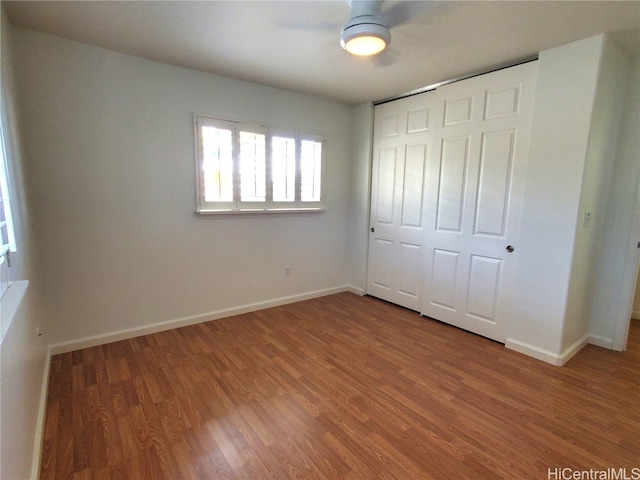 unfurnished bedroom with a closet, ceiling fan, and wood-type flooring