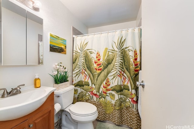 bathroom featuring curtained shower, vanity, and toilet