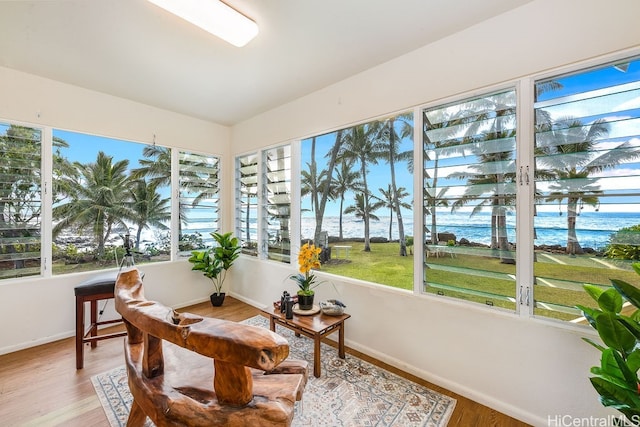 sunroom featuring a healthy amount of sunlight and a water view