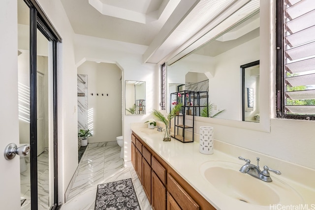 bathroom with a shower, vanity, and toilet