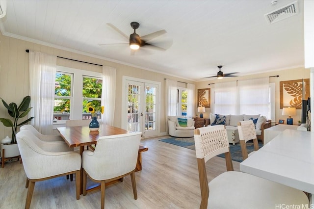dining area featuring visible vents, a ceiling fan, light wood-style flooring, and ornamental molding