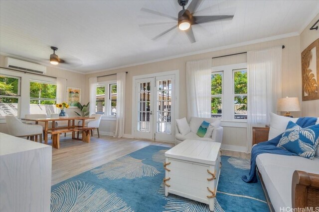living room featuring an AC wall unit, a ceiling fan, wood finished floors, and french doors
