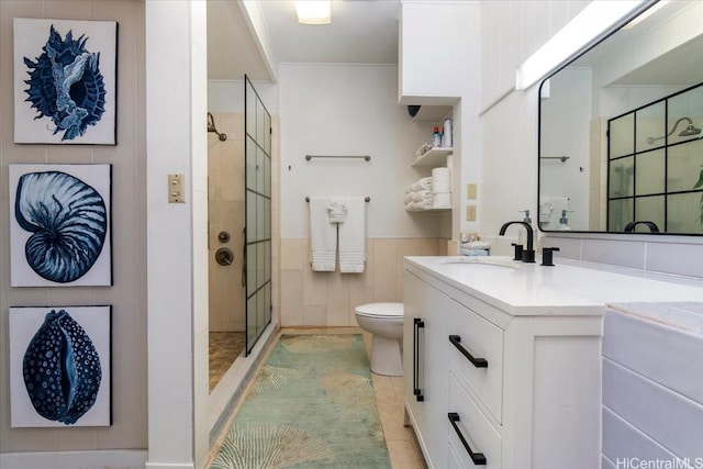 full bathroom featuring vanity, a wainscoted wall, toilet, and a shower stall