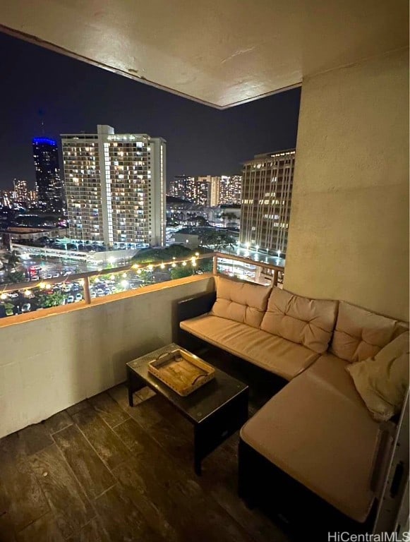 balcony at night featuring outdoor lounge area and a view of city lights