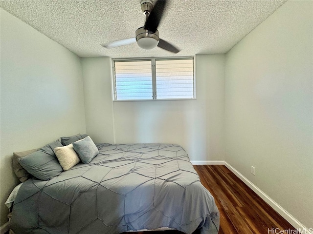 bedroom featuring ceiling fan, baseboards, a textured ceiling, and wood finished floors