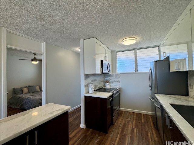 kitchen featuring dark hardwood / wood-style flooring, a textured ceiling, white cabinets, and appliances with stainless steel finishes