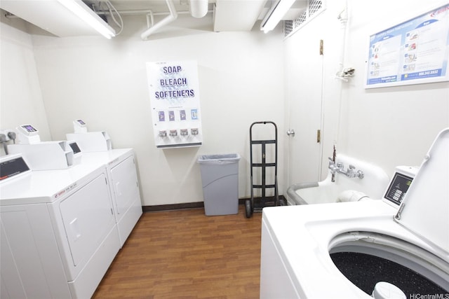 shared laundry area with wood finished floors, independent washer and dryer, and visible vents