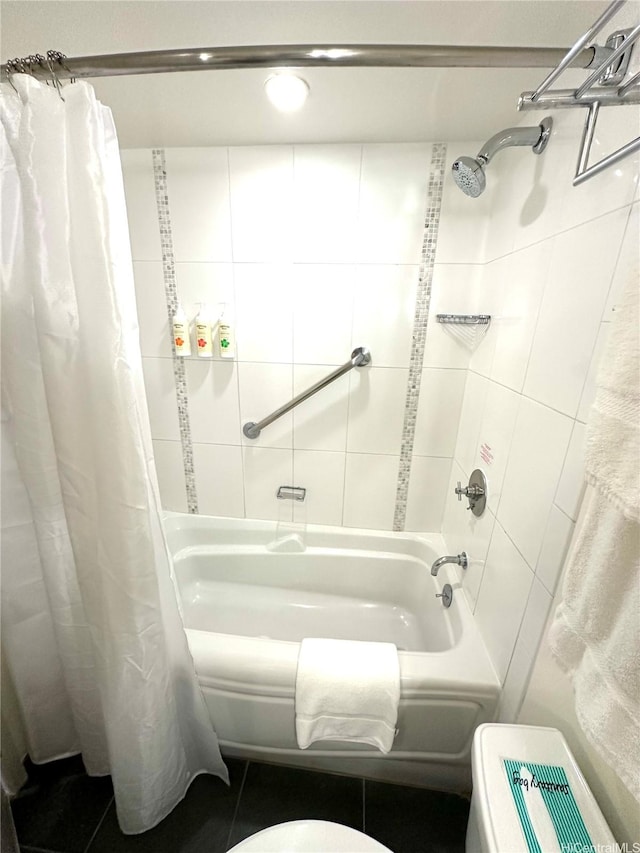 bathroom featuring tile walls, shower / bath combo with shower curtain, and toilet
