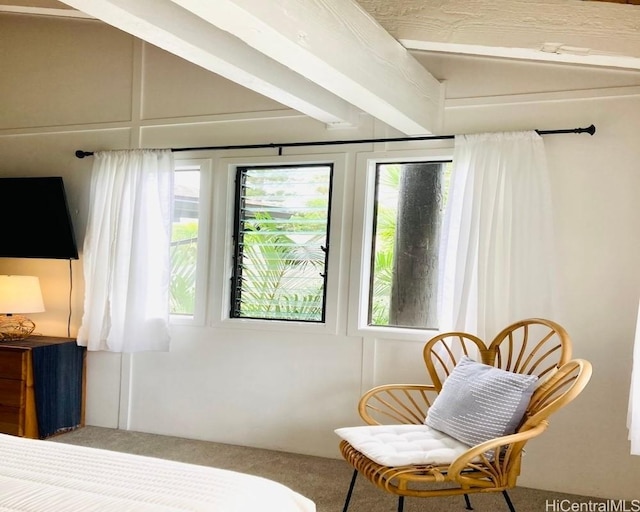 bedroom with beamed ceiling and carpet floors