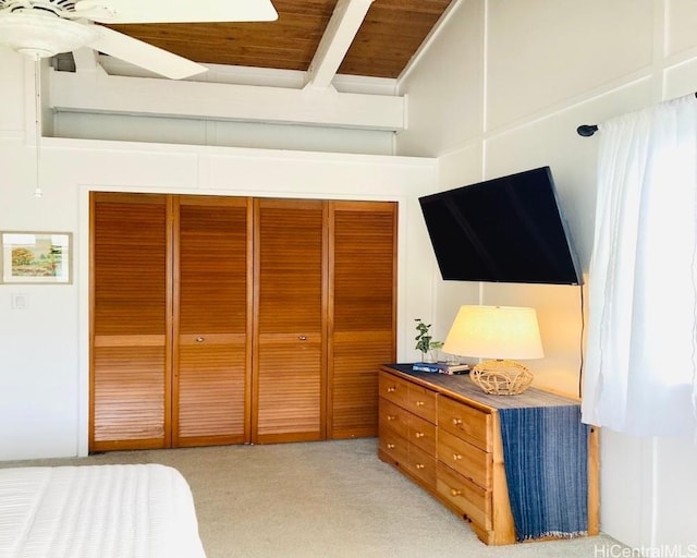 bedroom with beamed ceiling, light carpet, a closet, and wood ceiling