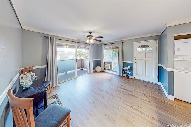 sitting room with stacked washer and dryer, ornamental molding, and hardwood / wood-style floors