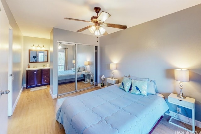 bedroom featuring ceiling fan, ensuite bath, a closet, and light wood-type flooring