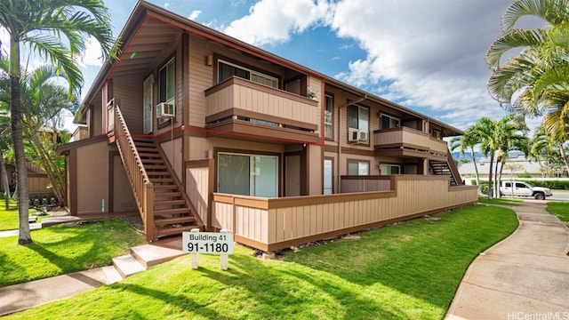 view of side of property with a balcony and a yard