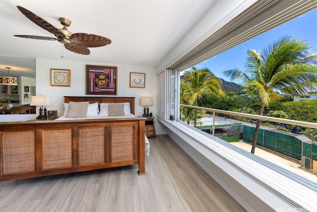 bedroom featuring light wood-type flooring, vaulted ceiling, and ceiling fan