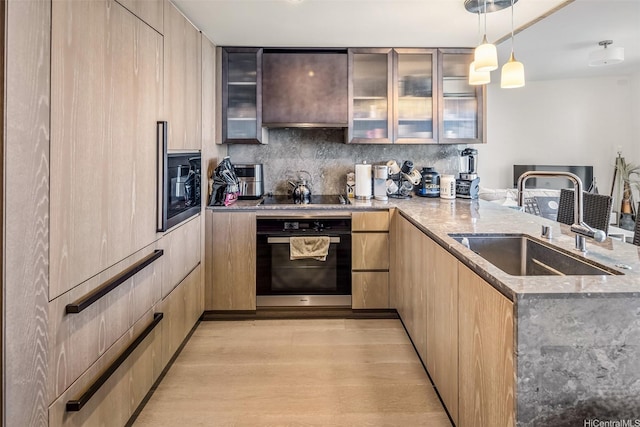 1000 Auahi St Unit 2506, Honolulu, HI 96814 - kitchen with black appliances, a peninsula, modern cabinets, light stone countertops, and a sink