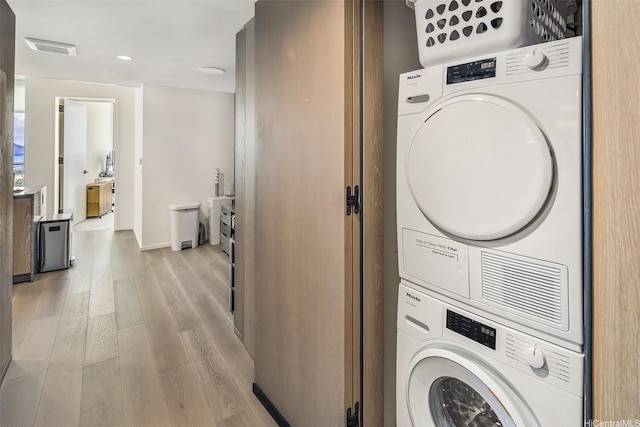 1000 Auahi St Unit 2506, Honolulu, HI 96814 - laundry room with estacked washer and dryer, light wood finished floors, baseboards, and recessed lighting