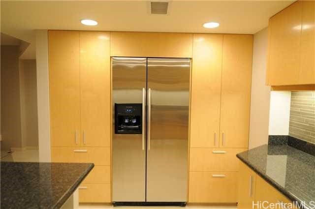 kitchen featuring tasteful backsplash, dark stone counters, light brown cabinets, and built in refrigerator