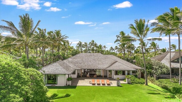 rear view of property featuring a lawn, an outdoor living space, and a patio