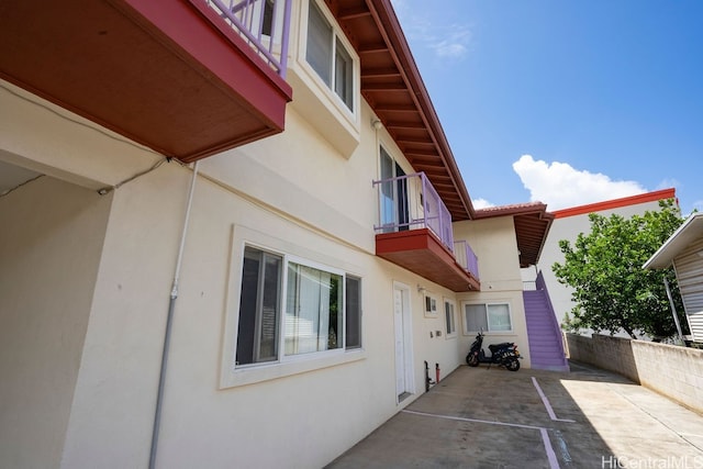 view of property exterior with a balcony and a patio area