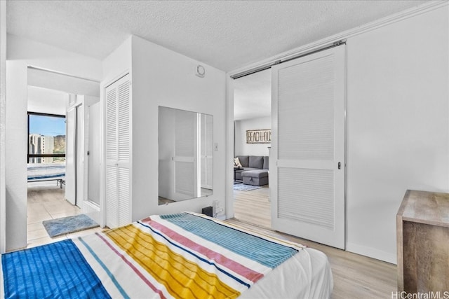 bedroom featuring a closet, light hardwood / wood-style floors, and a textured ceiling